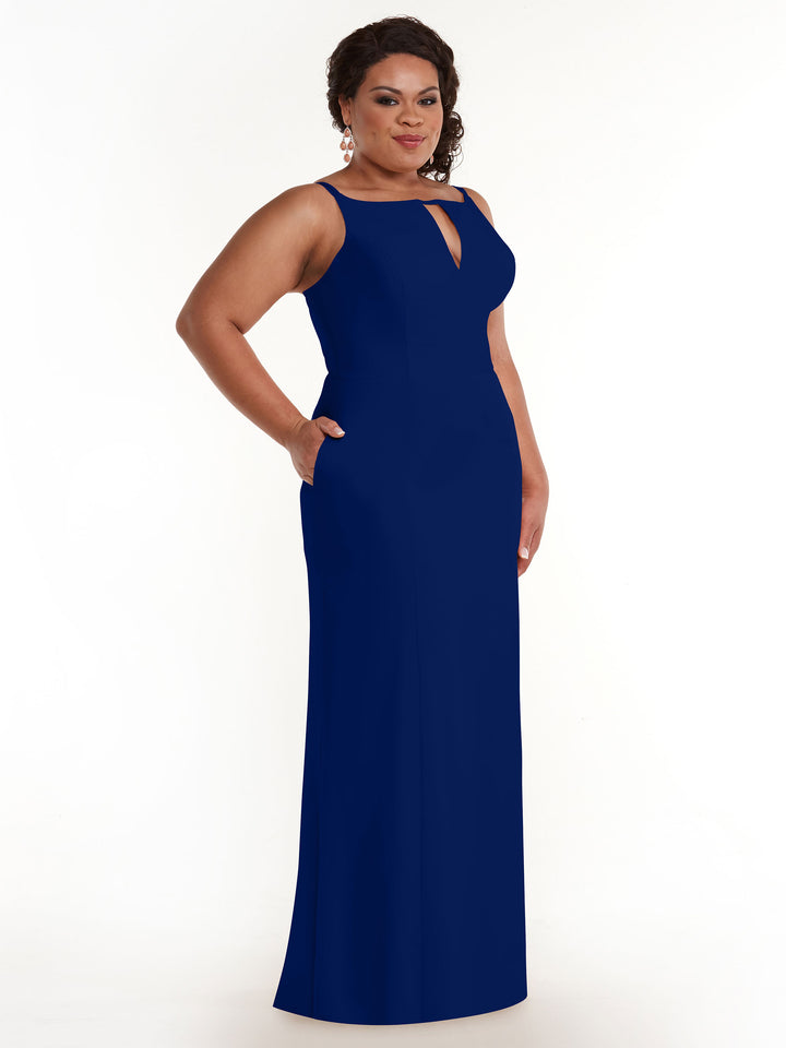 A woman models the Avery Austin 83030: a sleeveless, floor-length dark blue sheath dress with a keyhole neckline and pockets, posing against a plain white background.