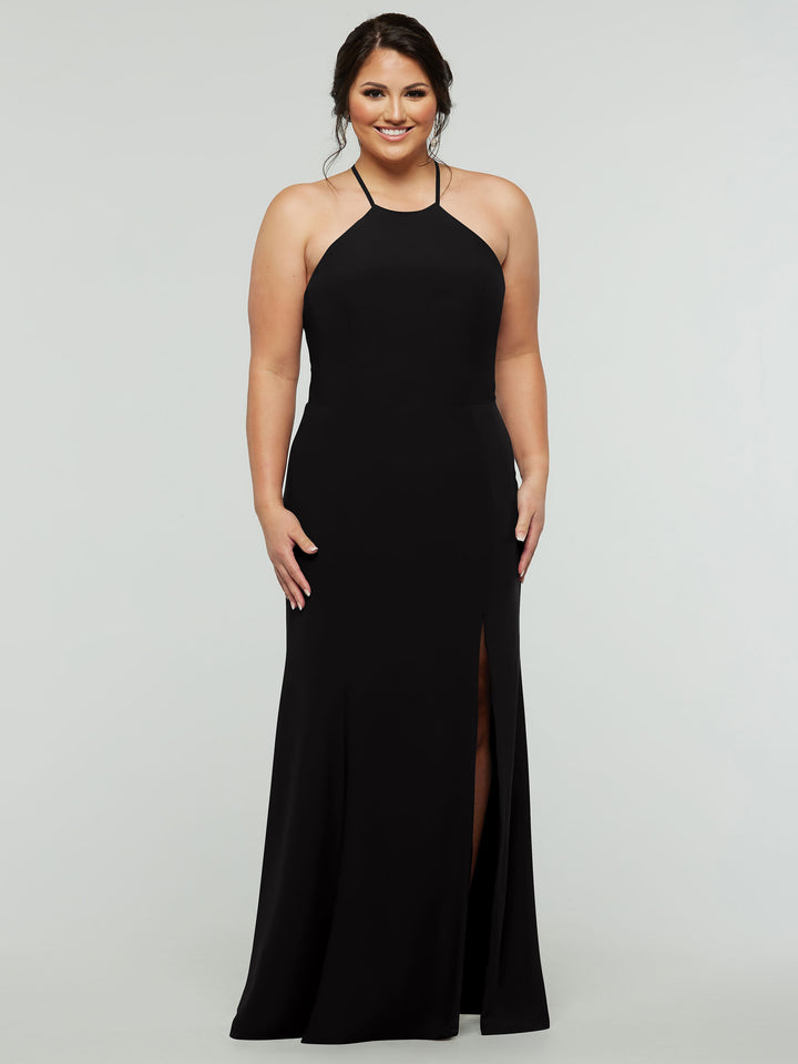 A woman smiles against a light gray background, wearing Avery Austin style 83031—a sleeveless, floor-length fitted black gown with a high neckline, front slit, and strappy back.