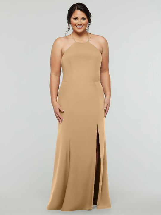 A woman poses against a light gray backdrop, smiling in the Avery Austin 83031 sleeveless tan halter dress with a high slit and her hair styled up.
