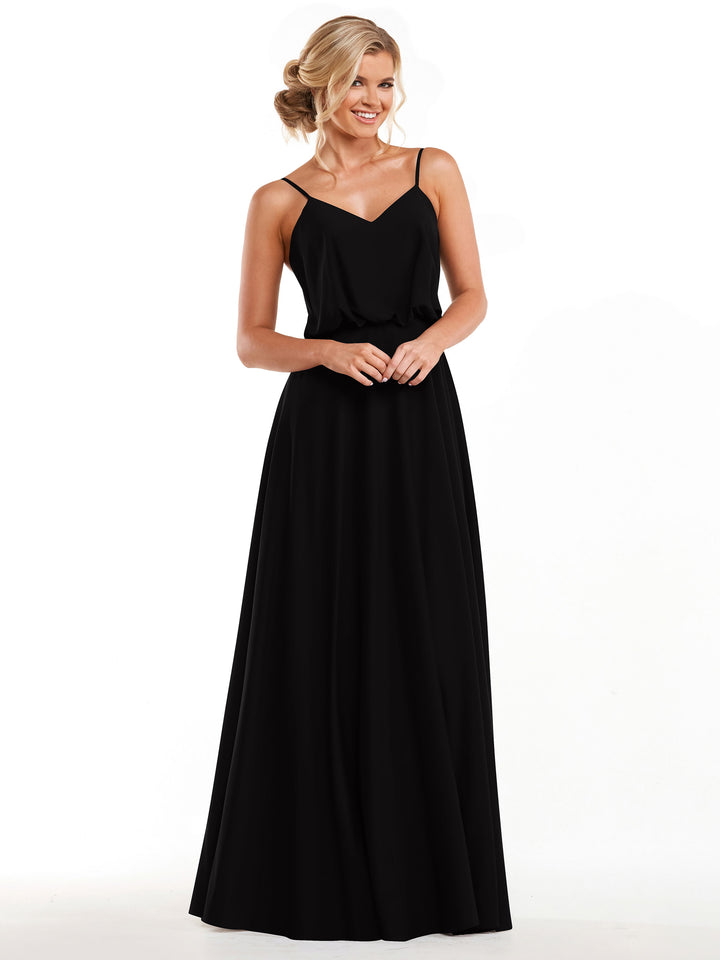 A woman stands smiling with hands clasped, wearing Avery Austin’s 83040—a long, sleeveless black A-line dress with thin straps and a flowy skirt. Her blonde hair is styled in an elegant updo against a plain white background.