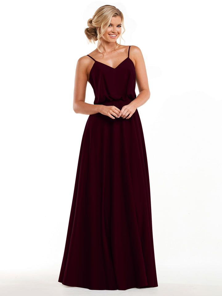A woman in the Avery Austin 83040 dress—a sleeveless, floor-length burgundy A-line with thin straps and flowy skirt—smiles against a white background. Her blonde hair is styled in a loose updo.