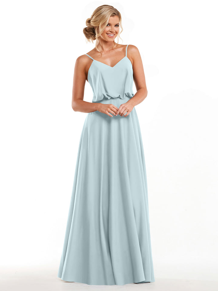 A woman stands smiling with hands clasped, modeling Avery Austin&