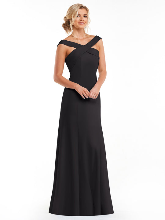 A woman smiles with her hands clasped, wearing Avery Austin’s 83048—an elegant black A-Line dress featuring an off-the-shoulder criss-cross neckline—against a white background.