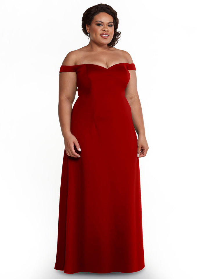 A woman wears the Avery Austin 83049 dress in ruby, a floor-length, off-the-shoulder A-Line design with a fitted bodice and flowing skirt, shown against a plain white background.