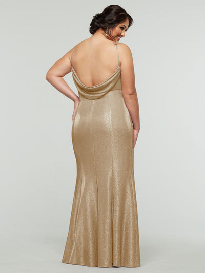 A woman stands facing away in the averyaustin 84001 - Tried On Sample: a glitter knit, floor-length gown with thin straps and a low draped back—an elegant choice shown against a plain light background.