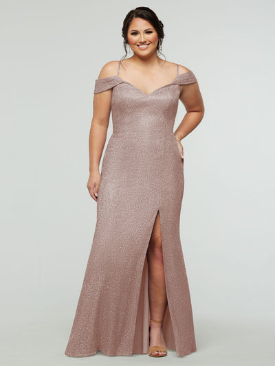 A woman in the averyaustin 84002 - Tried On Sample dress in Glitter Blush, featuring thin straps, off-the-shoulder style, and a thigh-high slit, smiles in nude heels against a plain background—perfect sample dress inspiration.