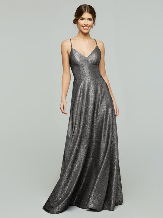 A woman wearing the averyaustin 84003 - Tried On Sample, a sleeveless Glitter Gun Metal A-Line dress with spaghetti straps, stands smiling against a plain light gray background.