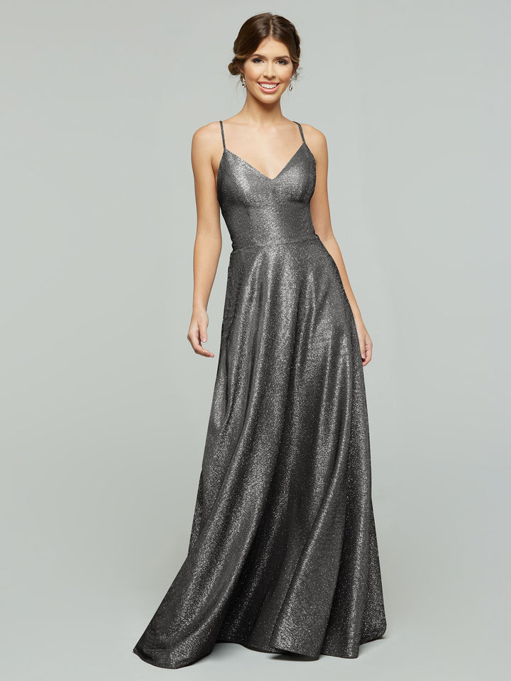 A woman wearing the averyaustin 84003 - Tried On Sample, a sleeveless Glitter Gun Metal A-Line dress with spaghetti straps, stands smiling against a plain light gray background.