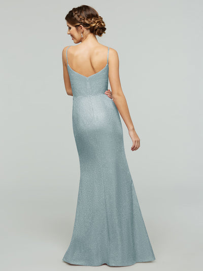 A woman with braided hair models the averyaustin 84008 - Tried On Sample: a sparkly, light blue, floor-length sheath dress with spaghetti straps and a V-back, posing against a plain light gray background while looking over her shoulder.